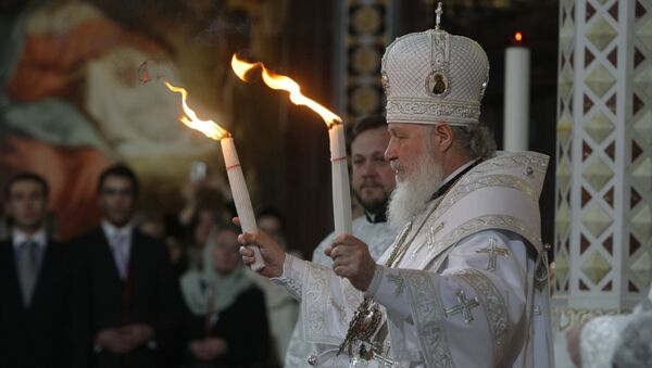 Patriarch Kirill of Moscow and All Russia handed the Holy Fire delivered from Jerusalem to all those thousands of faithful gathered at Moscow's Christ the Savior Cathedral on the Easter Night - Sputnik International