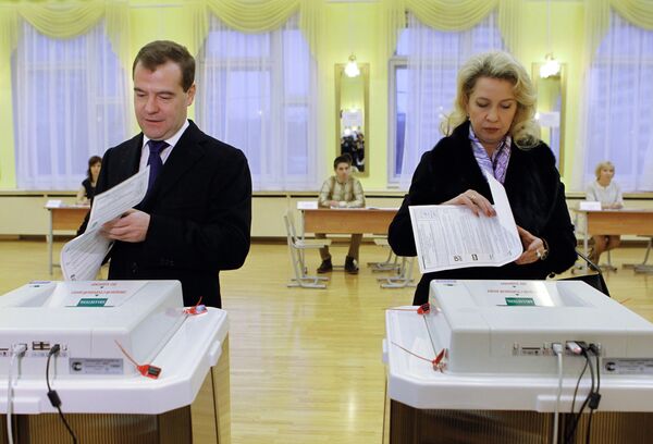 Russian President Dmitry Medvedev with his wife at a polling station - Sputnik International