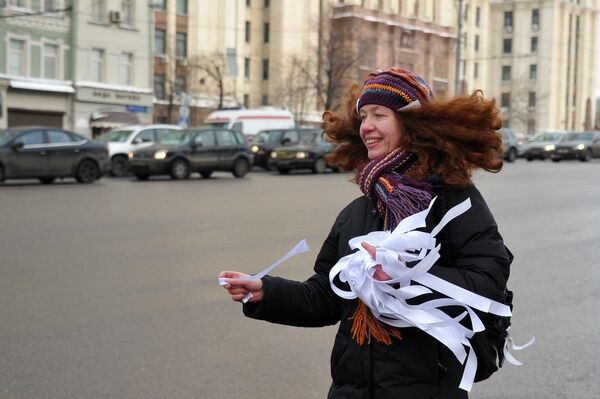 A woman distributes white ribbons at a protest in Moscow in February - Sputnik International