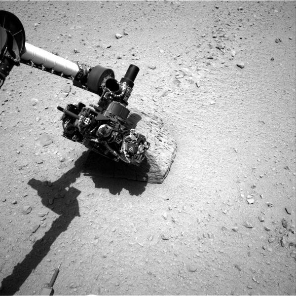 This image shows the robotic arm of NASA's Mars rover Curiosity with the first rock touched by an instrument on the arm. The rover's right Navigation Camera (Navcam) took this image during the 46th Martian day, or sol, of the mission (Sept. 22, 2012) - Sputnik International