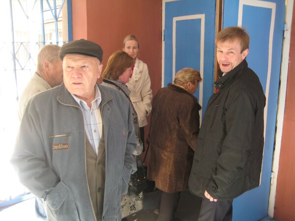 Urlashov, right, holding the door for voters at a polling station on Sunday. - Sputnik International