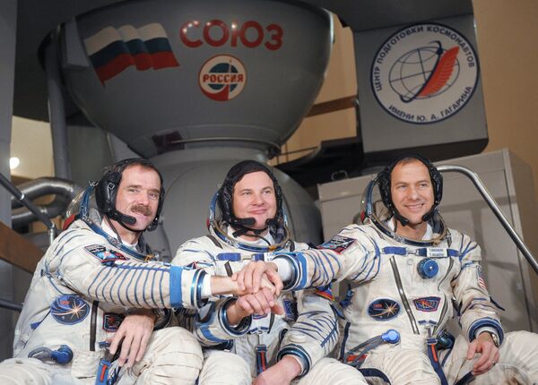 The crew members are Chris Hadfield of Canada (L), Roman Romanenko of Russia (C) and Thomas Marshburn of the United States (R). Archive. - Sputnik International