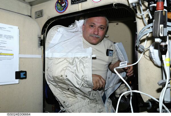 With most of his body tucked away in a sleeping bag, Russian cosmonaut Fyodor Yurchikhin, Expedition 24 flight engineer, is pictured in his crew quarters compartment in the Zvezda Service Module of the International Space Station - Sputnik International
