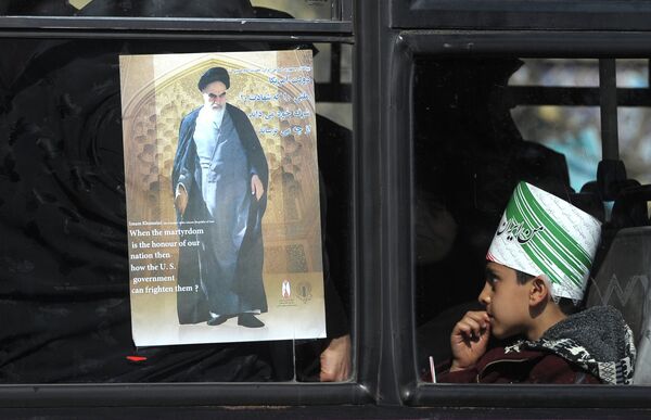 A city bus navigating traffic in Tehran earlier this month, adorned with an image of Ayatollah Khomeini. - Sputnik International