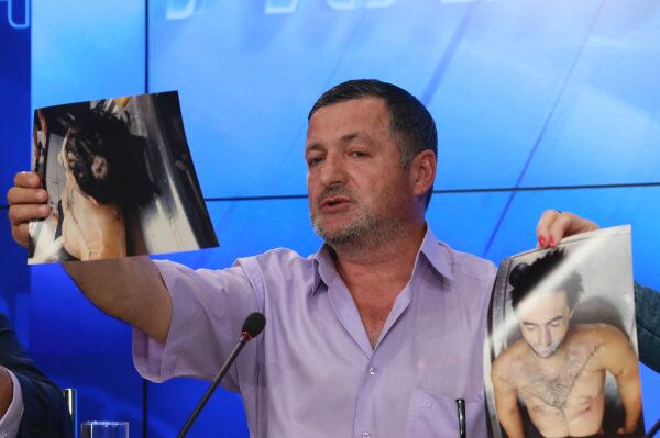 Abdulbaki Todashev, Ibraghim's father, holds up photos of his dead son at a press conference at the RIA Novosti headquarters in Moscow on May 30. - Sputnik International