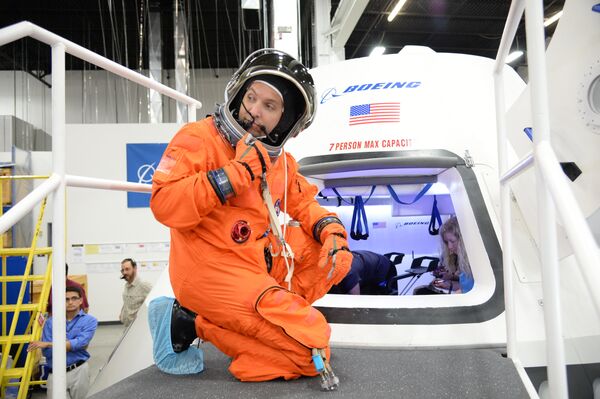 NASA astronaut Randy Bresnik prepares to climb inside a model of Boeing’s CST-100 spacecraft. - Sputnik International