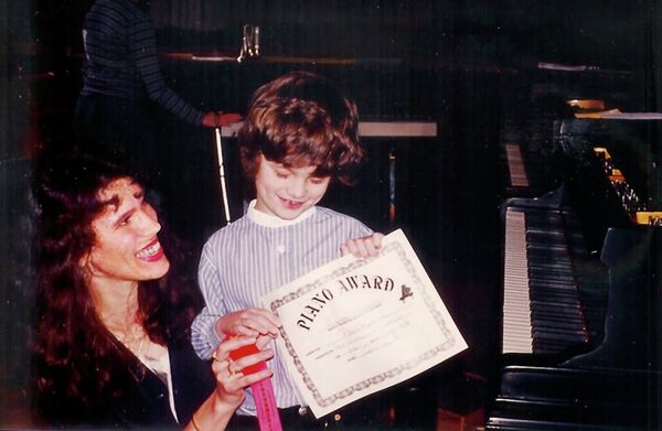 Anton Sviridenko's mother Julia Swerdlov looks on proudly as he receives his first music award at the age of 5. - Sputnik International