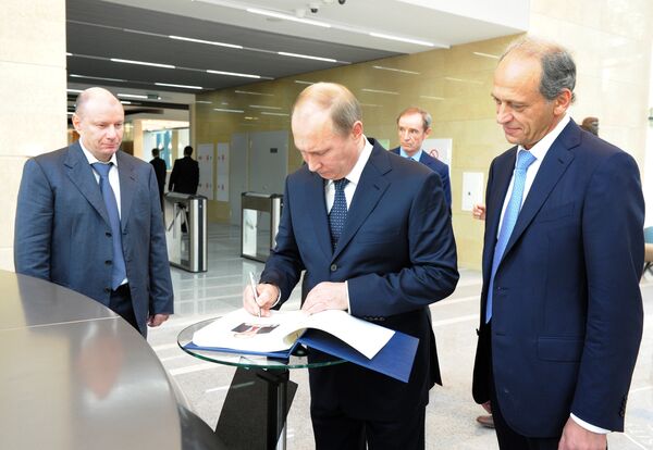 Vladimir Putin signing a guestbook in the university building's lobby - Sputnik International