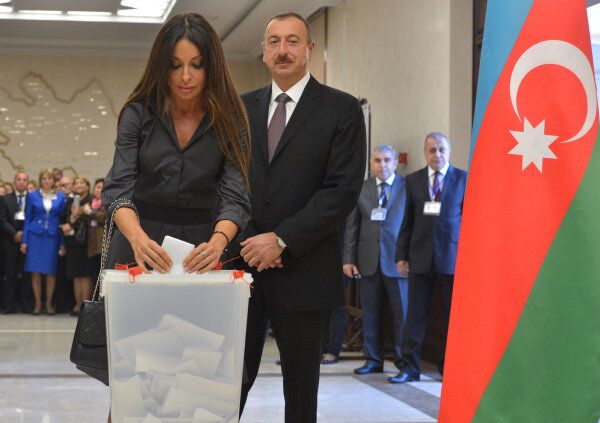 Incumbent Azerbaijani President Ilham Aliyev watches his wife, Mehriban, cast her vote for the presidential election at a polling station in Baku, the country's capital, on Wednesday. - Sputnik International
