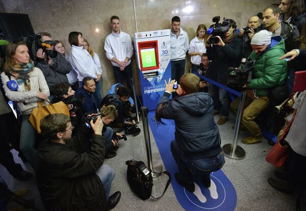 A man squats in Moscow metro to get a ticket from olympic ticket mashine - Sputnik International