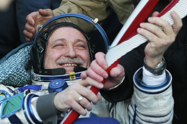 Russian cosmonaut Fyodor Yurchikhin with the Olympic torch in his hands after a capsule of the Soyuz TMA-09M spacecraft under his command lands in Kazakhstan. - Sputnik International