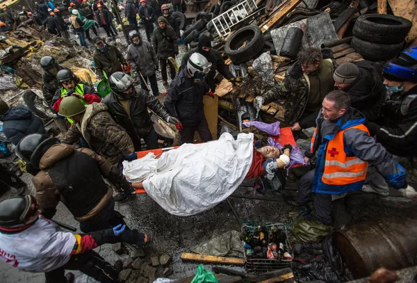 Protesters carry an injured comrade during a clash with riot police in Kiev Protesters carry an injured comrade during a clash with riot police in Kiev - Sputnik International
