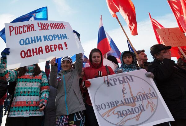 Supporters of Crimea referendum results holding posters with captions: Welcome home, Crimea! and Russia-Ukraine - same origins, same faith! - Sputnik International