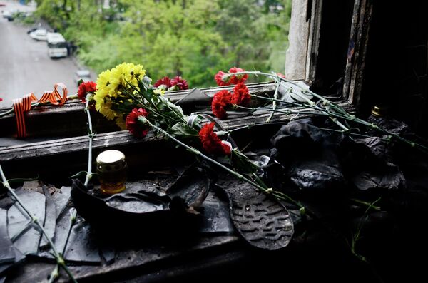 Flowers on a broken window in memory of the people killed by fire in the Trade Unions House - Sputnik International