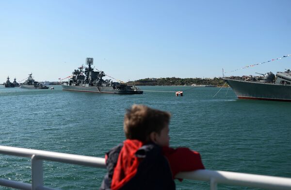 A child watches naval ships in the Bay of Sevastopol - Sputnik International
