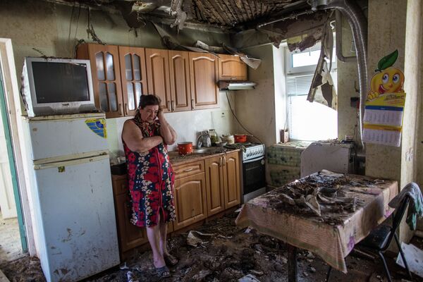 A woman in her house damaged during the night artillery attack conducted by Ukrainian troops on the outskirts of Slavyansk - Sputnik International