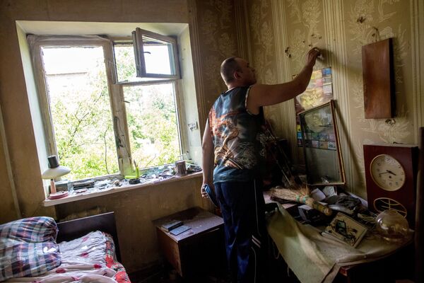 A resident of Slaviansk at his home after a bomb exploded in his courtyard - Sputnik International