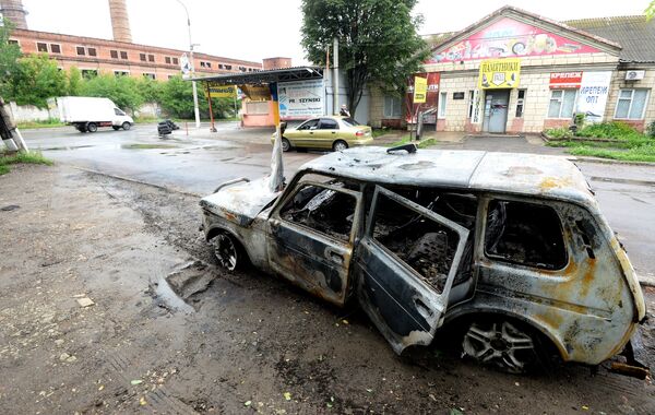 A car burnt during an artillery shelling of the Ukrainian army in Luhansk - Sputnik International