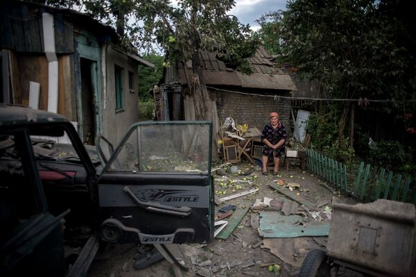 A resident of Luhansk near near her house destroyed by an artillery attack by Ukrainian army - Sputnik International