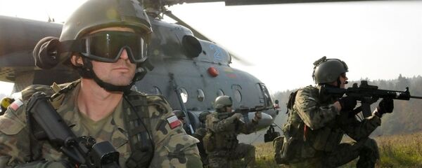 A Polish Special Operations Forces Command soldier, left, provides security alongside U.S. Special Forces Soldiers before exfiltrating on a Lithuanian Mi-17 helicopter as part of a downed aircraft exercise rehearsal held Oct. 14 at the Joint Multinational Readiness Center in Hohenfels, Germany. - Sputnik International