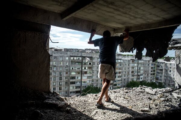 A man in a residential building hit by an artillery strike by Ukraine's armed forces - Sputnik International