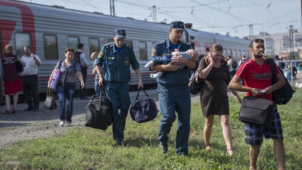 Russian Emergencies Ministry's employees help Ukrainian refugeesas they arrive in Russia's Omsk. - Sputnik International