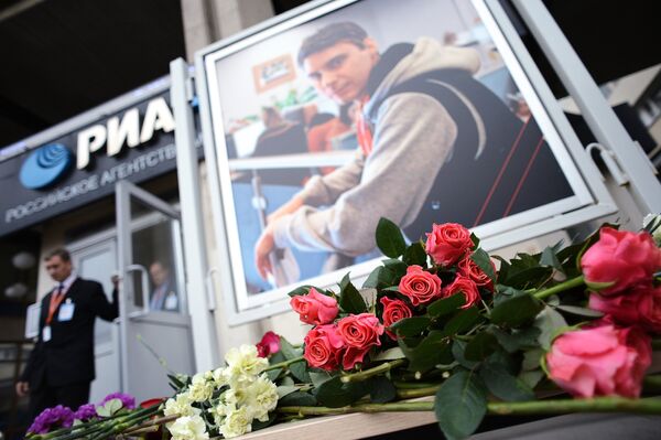 People bring flowers to Rossiya Segodnya HQ in memory of photographer Andrei Stenin, who was killed in Ukraine - Sputnik International
