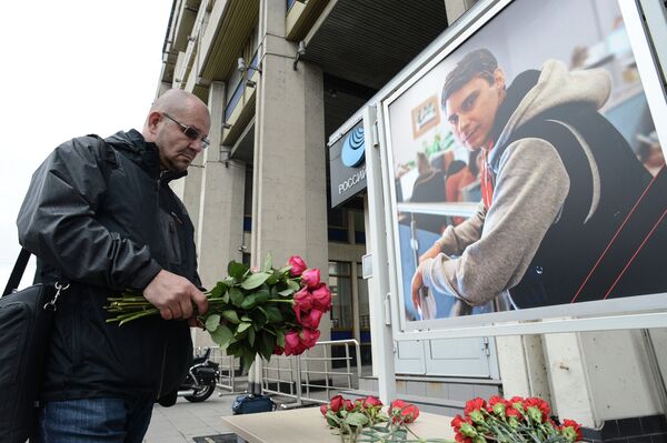 A colleague lays flowers in memory of the Russian journalist Andrei Stenin, who was killed in Ukraine. - Sputnik International