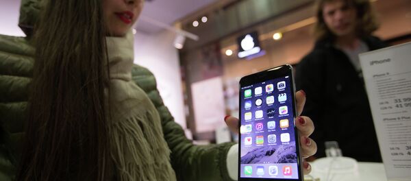 A woman taking a look at the new iPhone in one of Russia's official iPhone resellers; it may now be cheaper to buy a contract-free iDevice in Russia than elsewhere. - Sputnik International