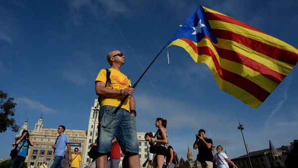 Catalans are expected to turn out in droves on Sunday to make their strongest show of force to date for breaking away from the rest of Spain in a symbolic independence vote. Above: A man holds a pro-Catalan independence flag known as the Estelada. - Sputnik International